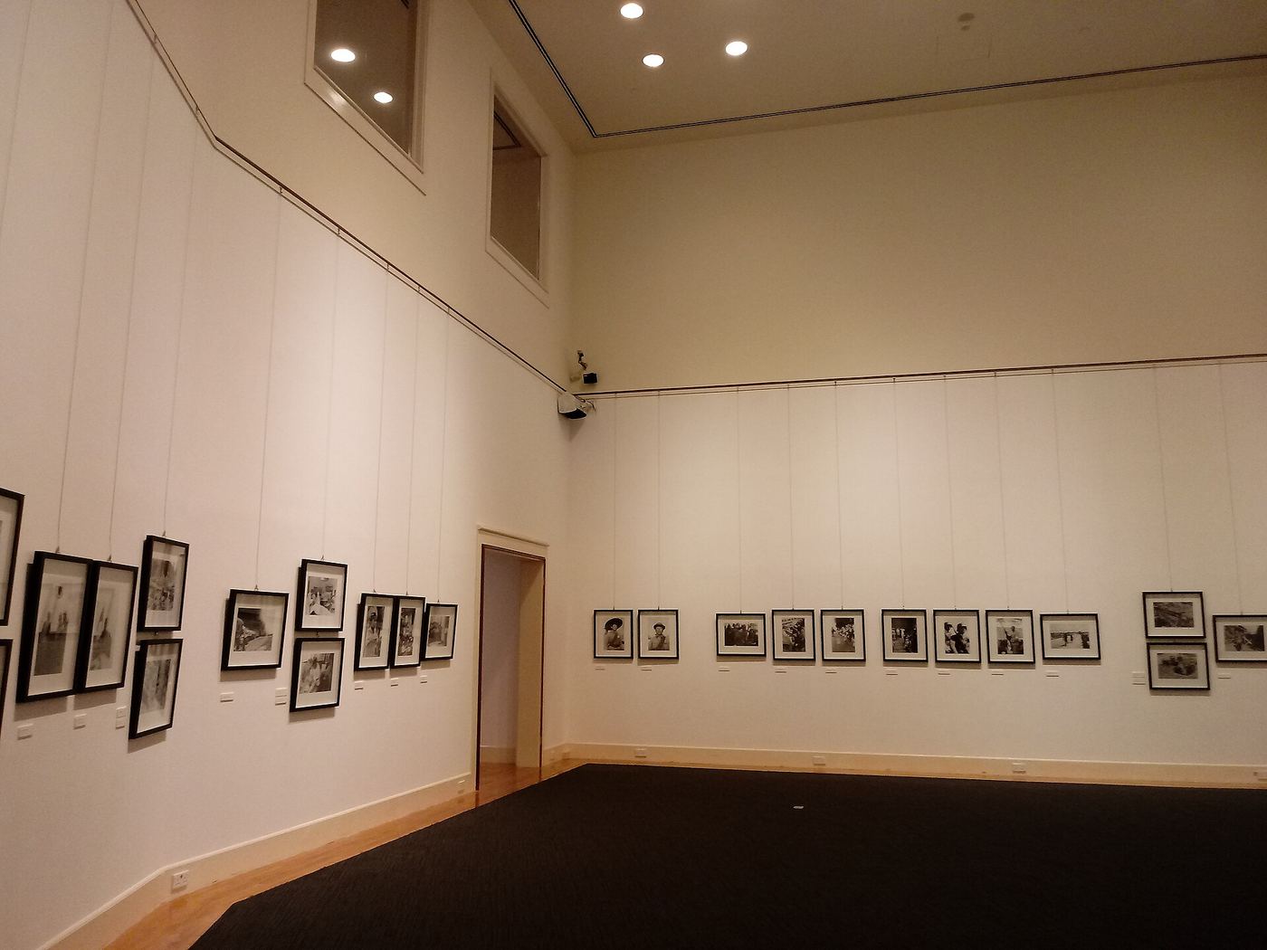 Gallery corner with rows of small framed black-and-white works