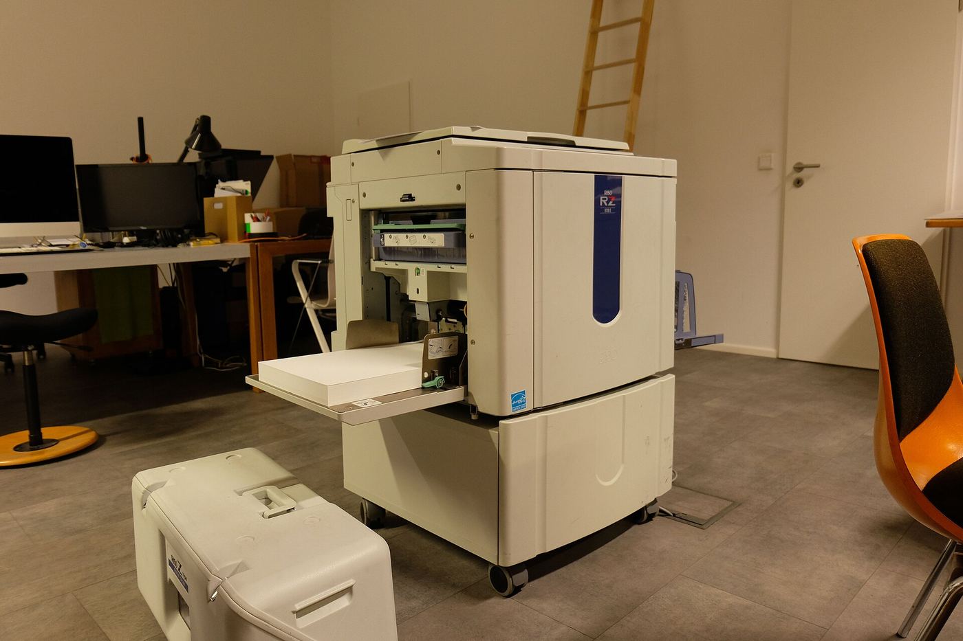 Risograph printer in a studio office with a stack of paper in the tray