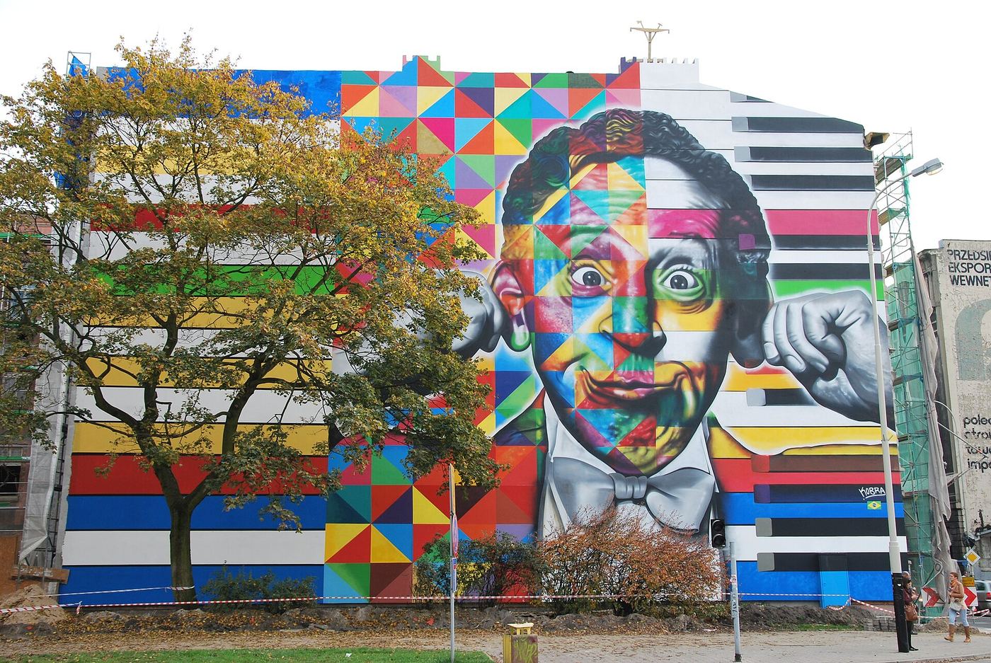 Giant colourful mural of a man with his fingers in his ears painted across an apartment block