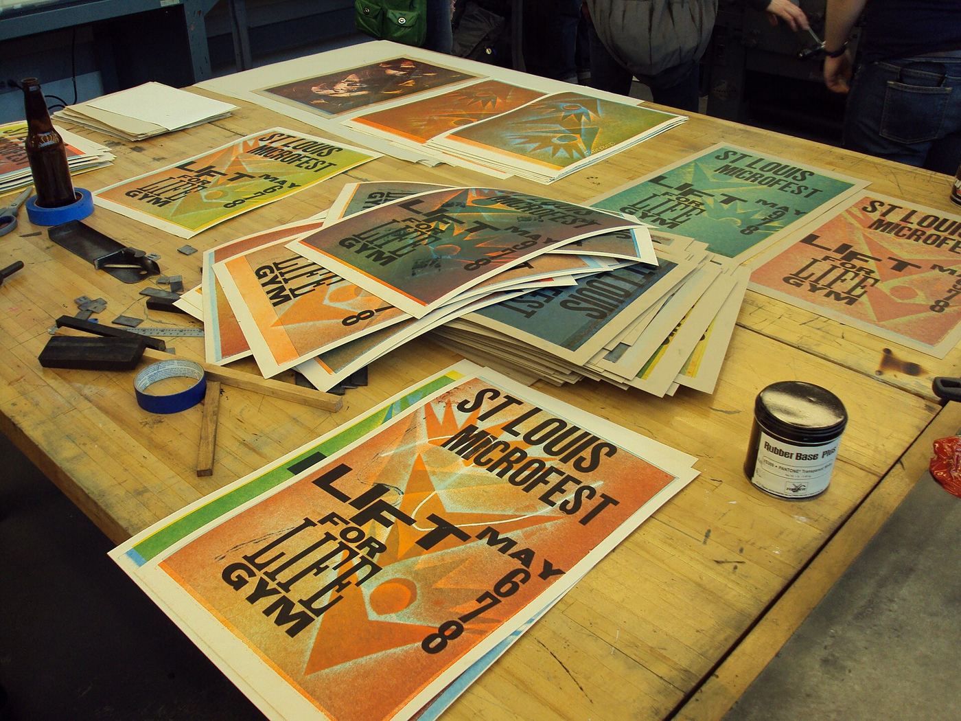 Colourful letterpress posters drying across a workshop table